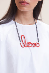 Red leather women's short with distinctive love-link metal necklace